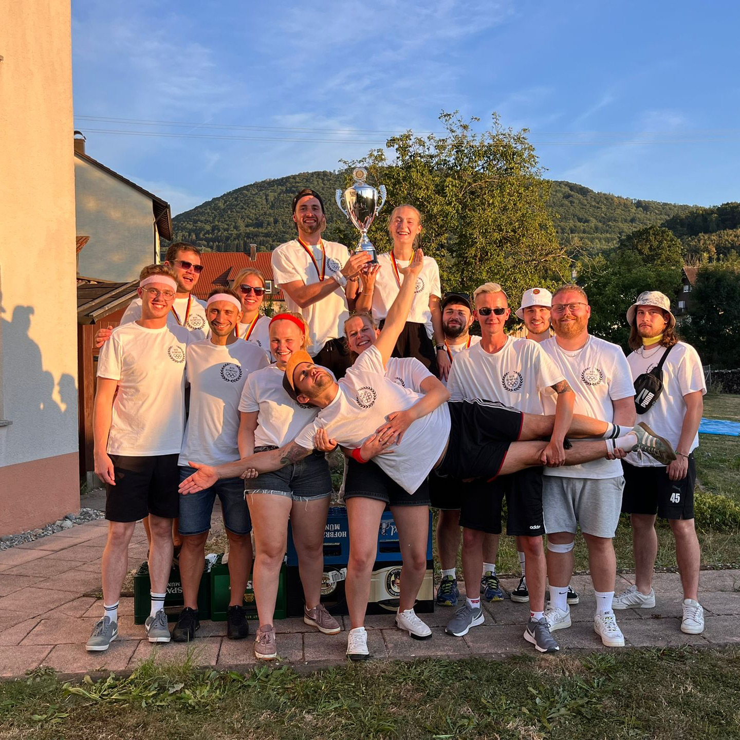 Siegerteam mit Pokal im Abendlicht